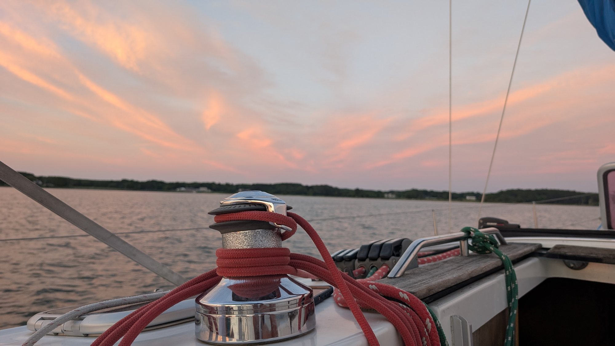 A winch wrapped in coral line at sunset, calm water beyond