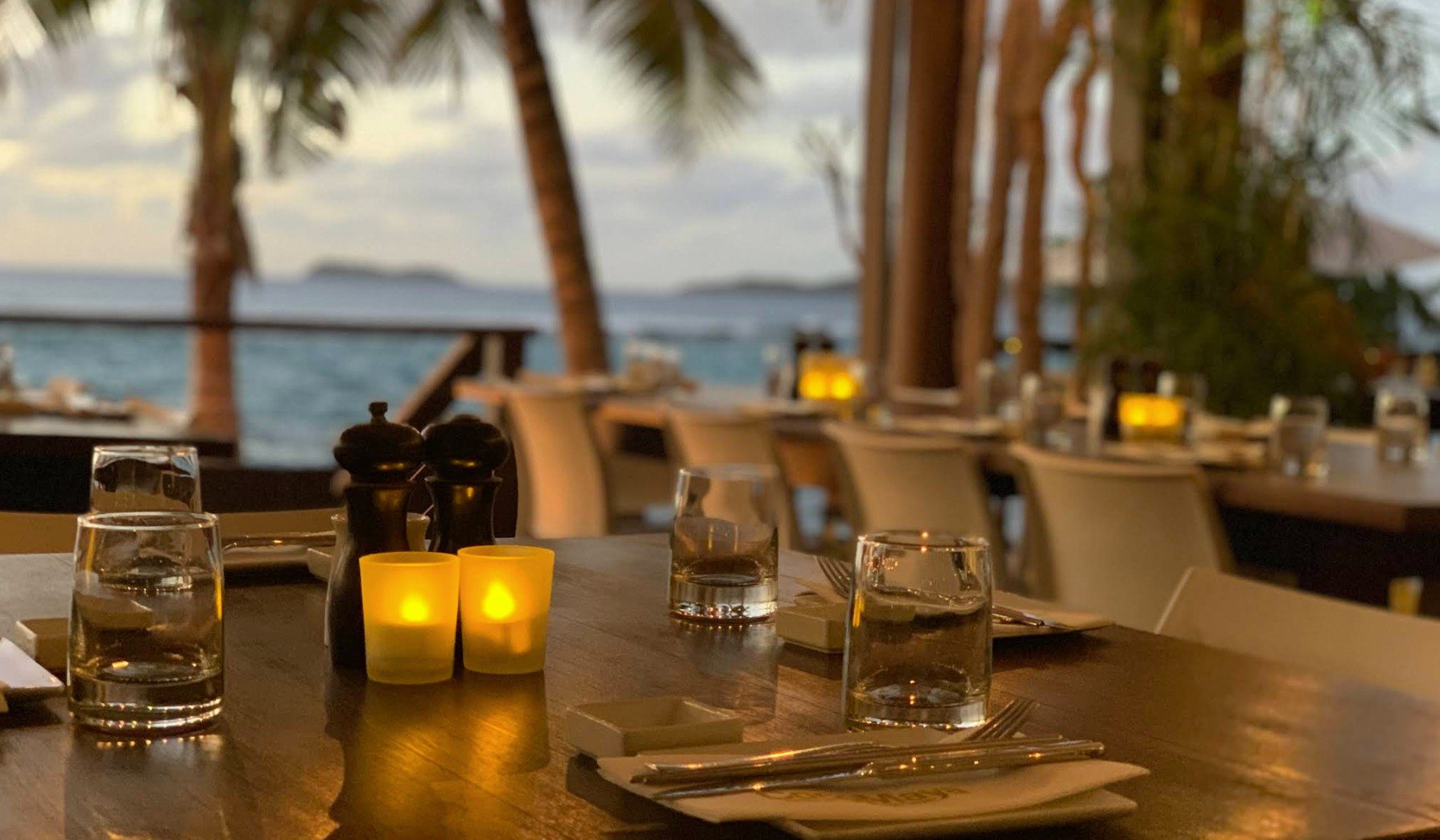 A candlelit table by the sea at dusk, Virgin Gorda