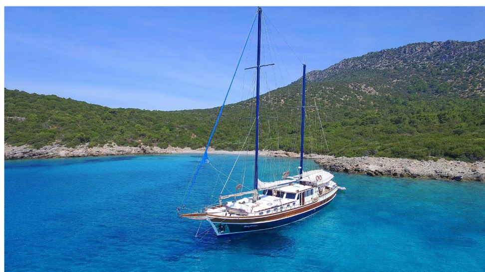 A gulet at anchor in a turquoise cove