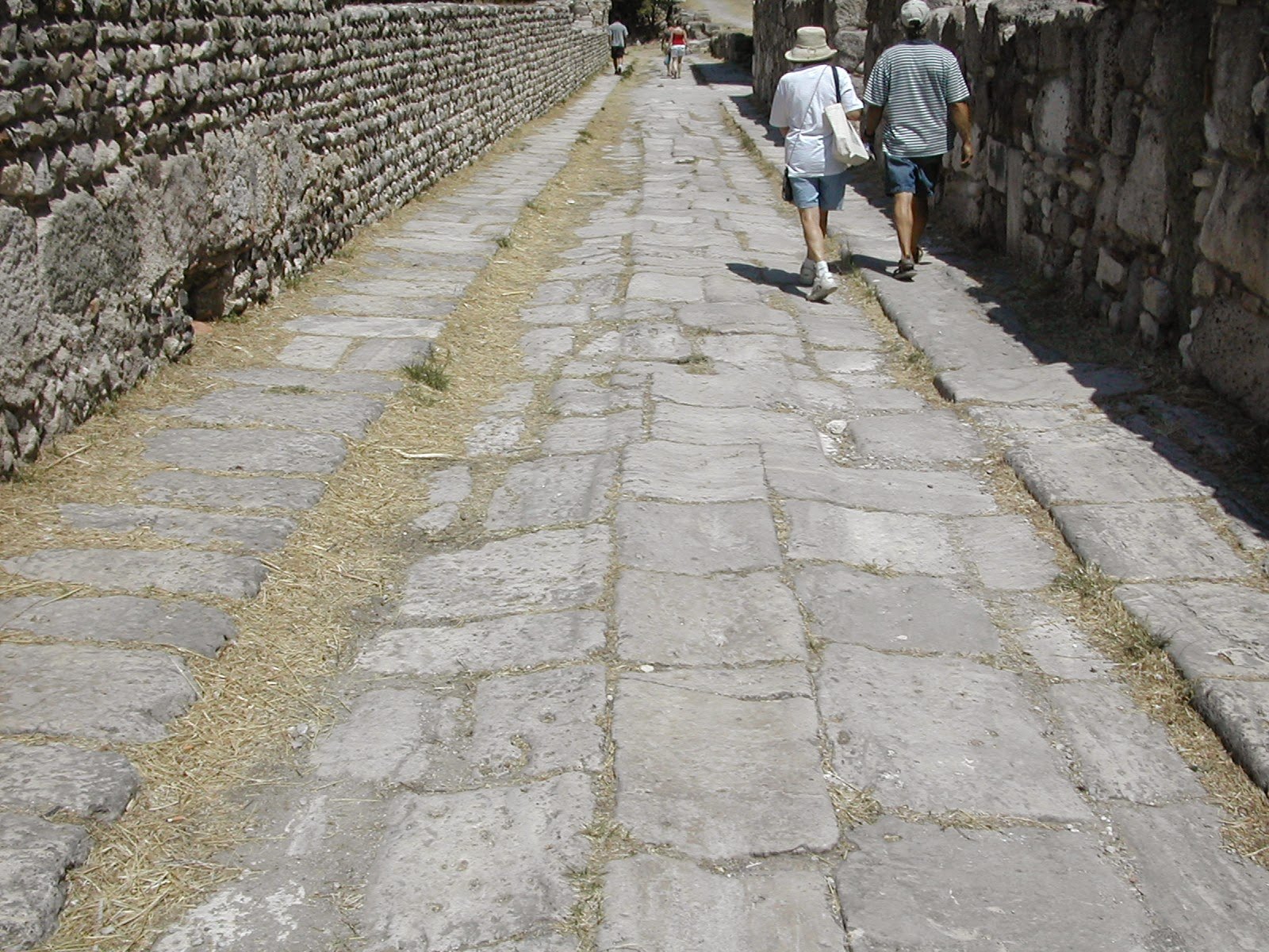 Travelers walking an ancient paved street