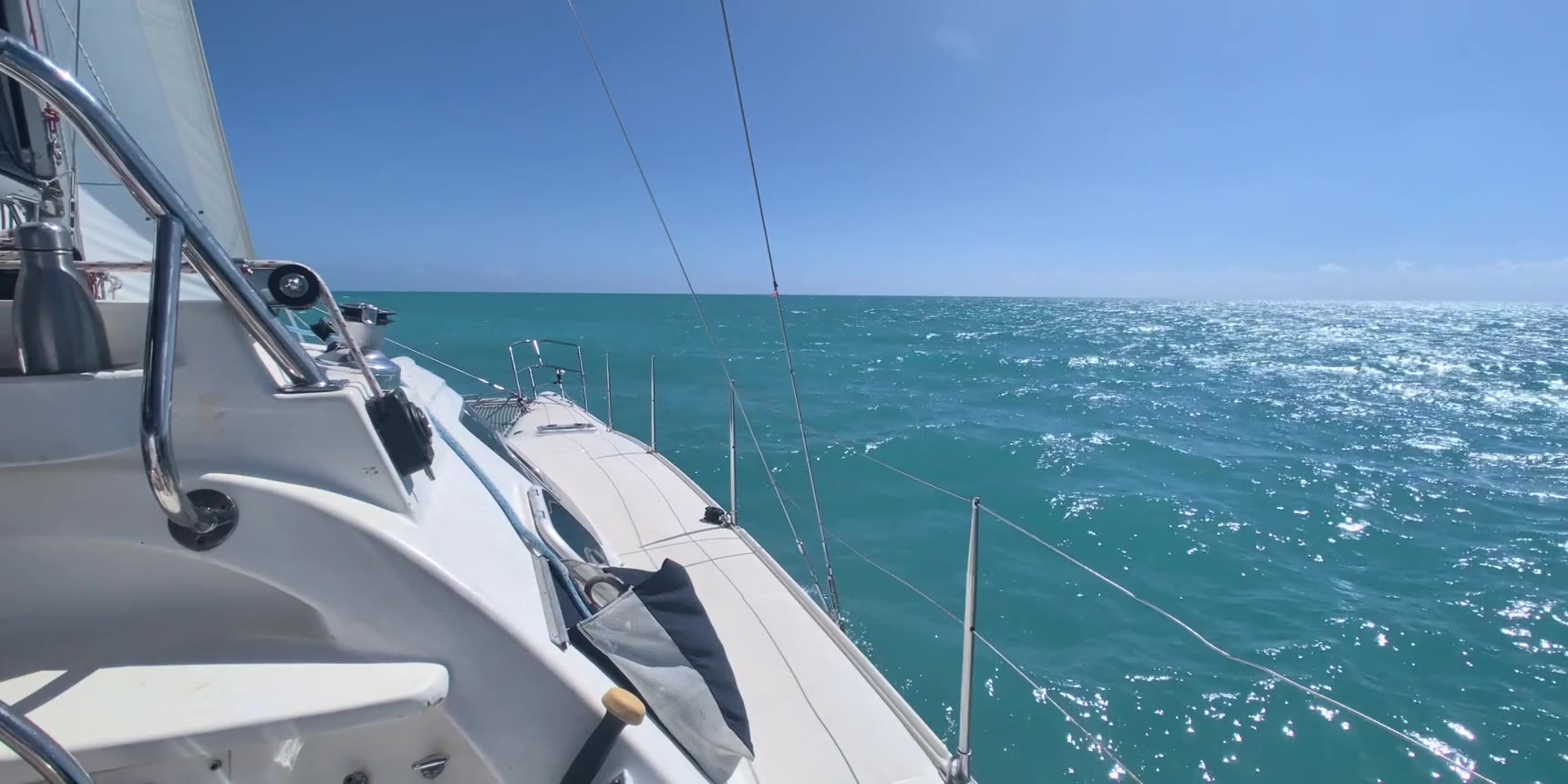 Underway — deck and sails, open water ahead