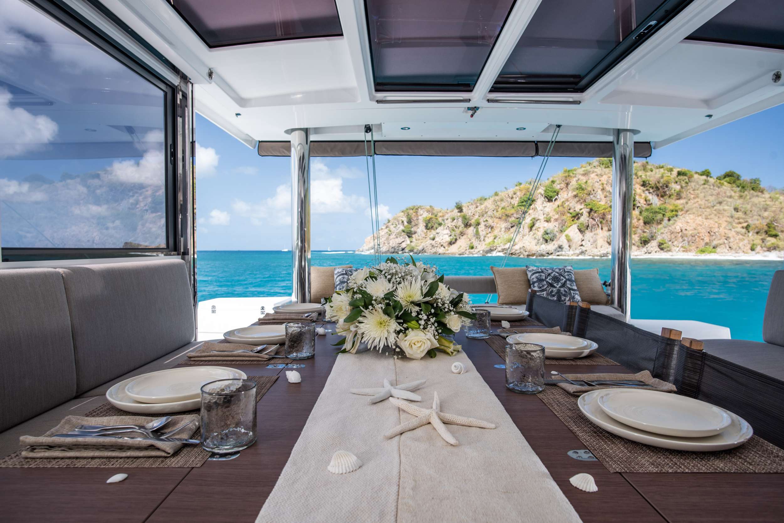 The cockpit table set for lunch, an island across the water
