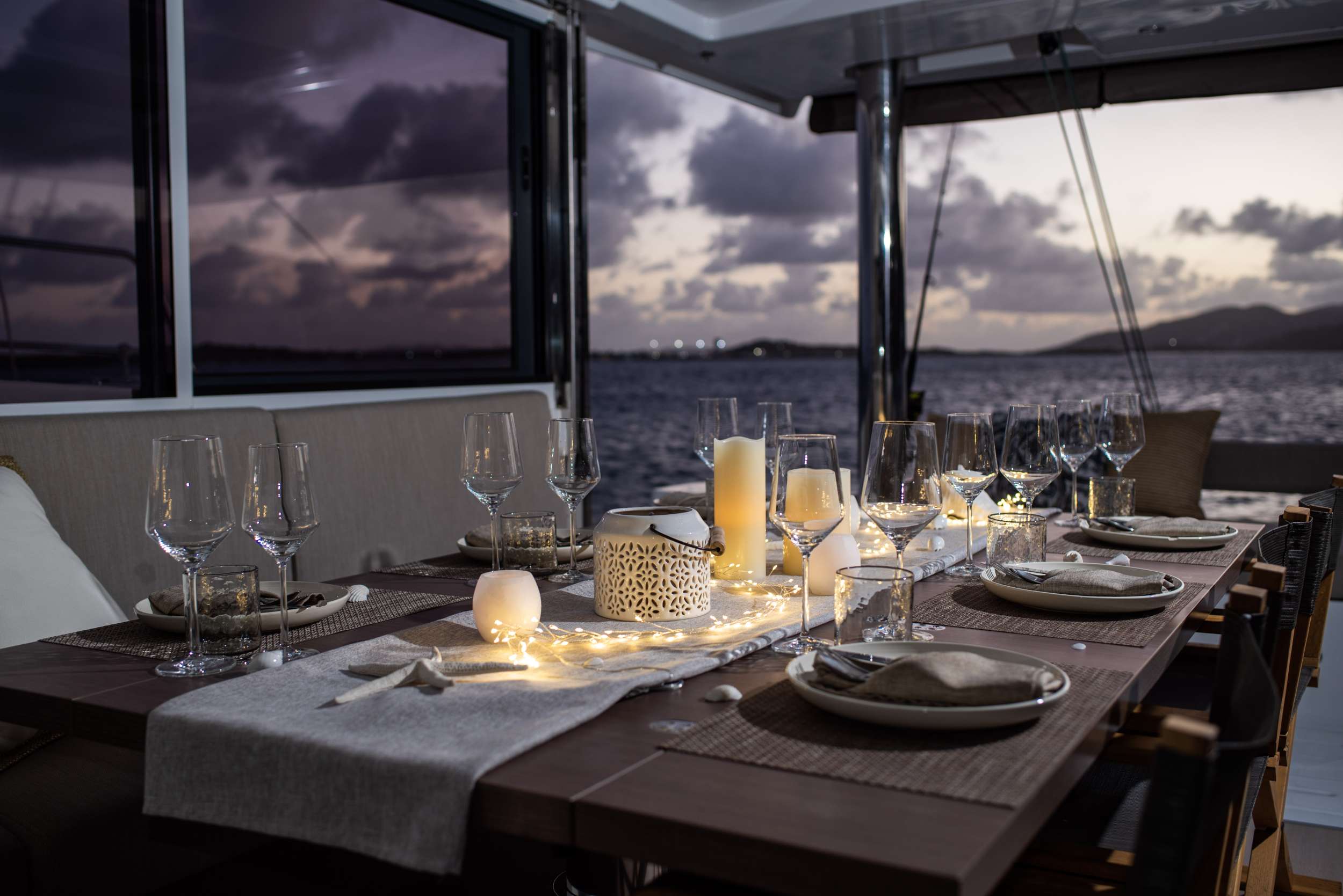 The table set at dusk on deck — the evening toast